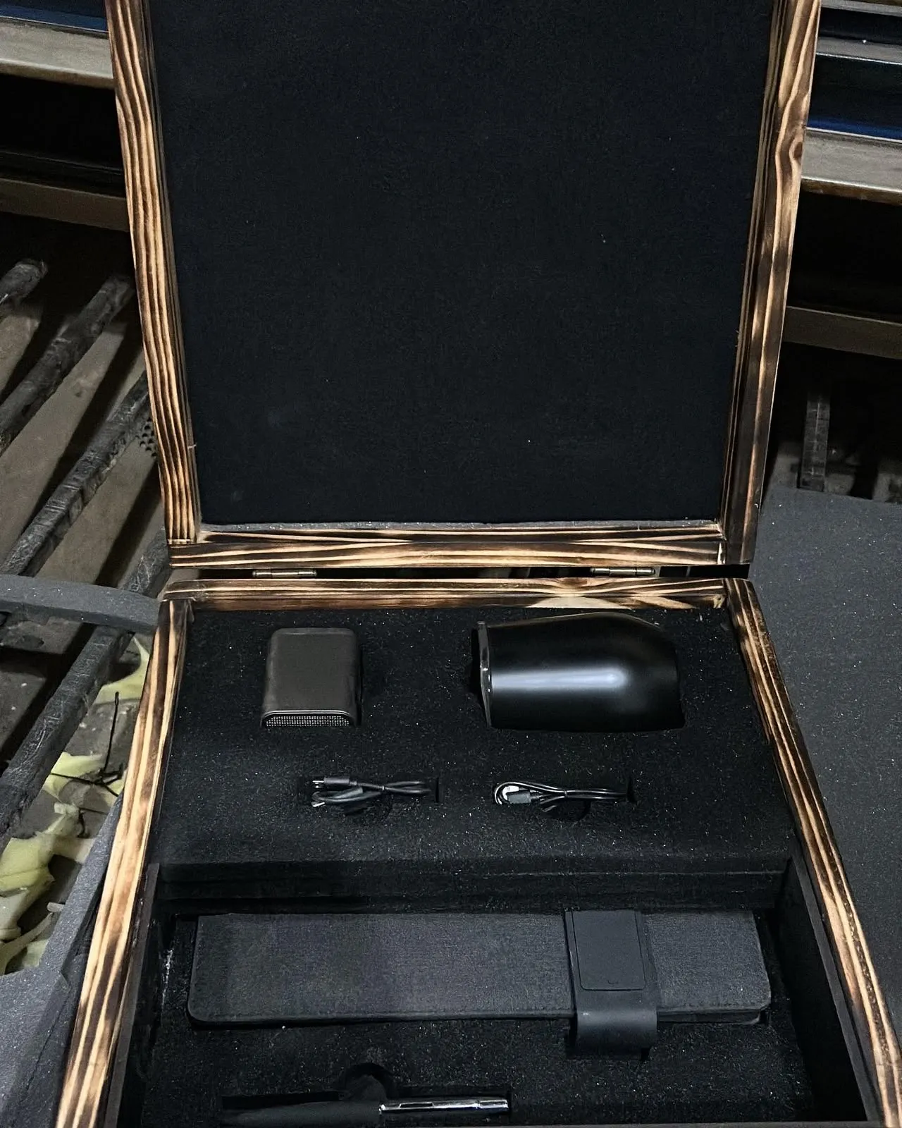 Caja de madera quemada abierta con interior de espuma troquelada