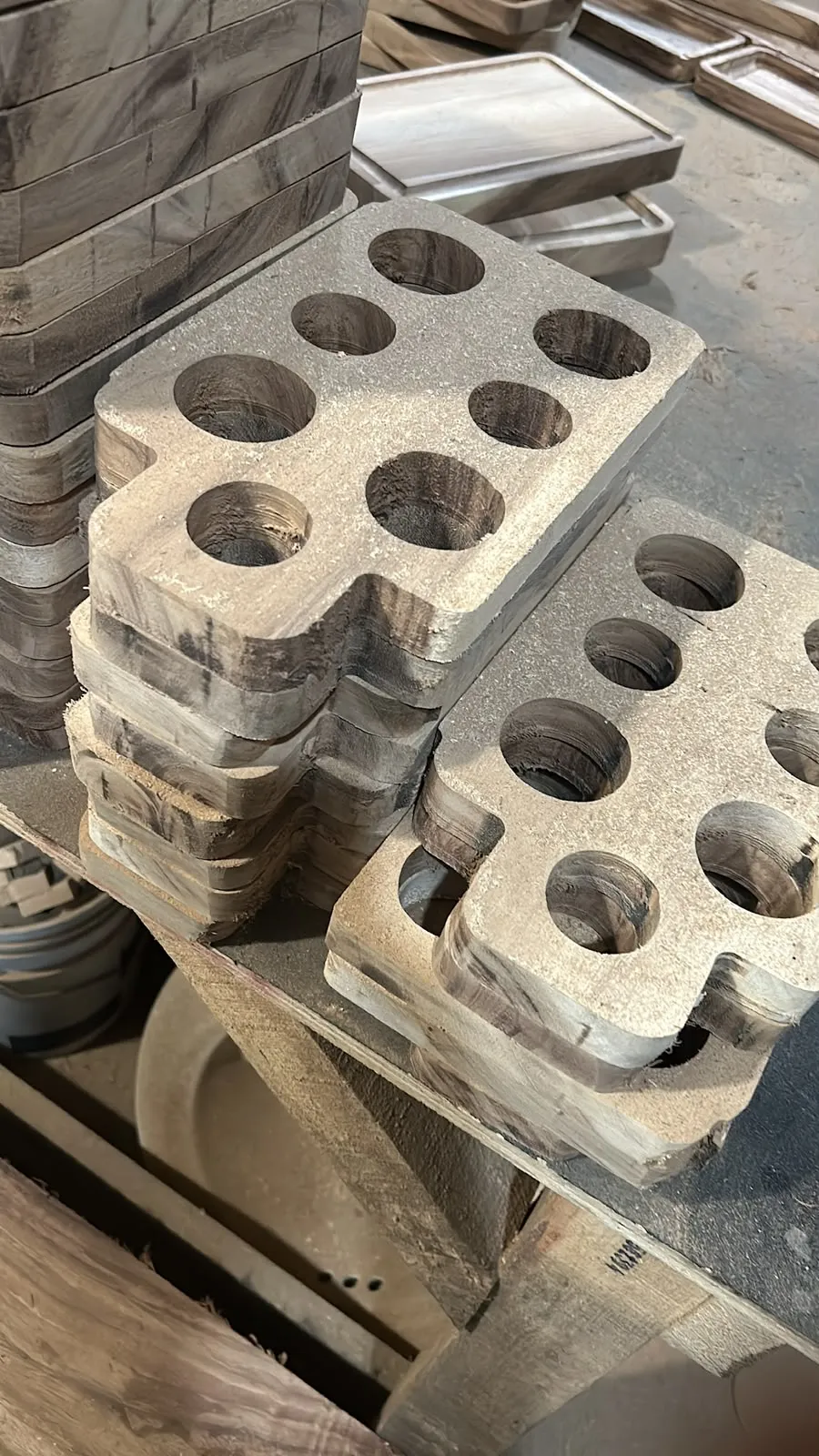 Bases de madera perforadas para portavasos apiladas en bruto